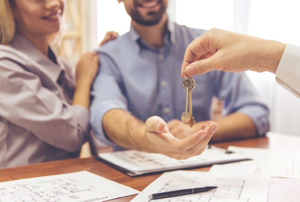 Close-up of hands holding house keys with Boise foothills background