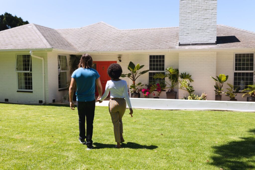Happy couple walking toward their new Meridian Idaho home after successfully navigating a competitive real estate market.