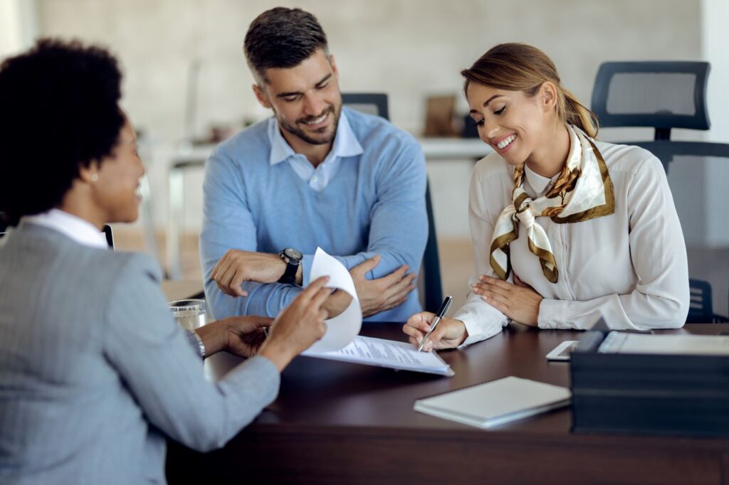 Couple signing an Idaho real estate contract with their agent to secure a Boise home purchase before a seller rescinds.